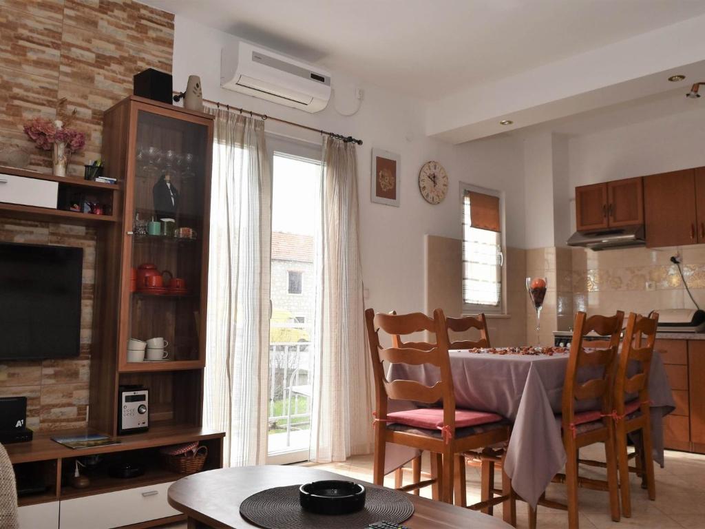 uma cozinha e sala de jantar com mesa e cadeiras em Apartment Manigo em Supetar