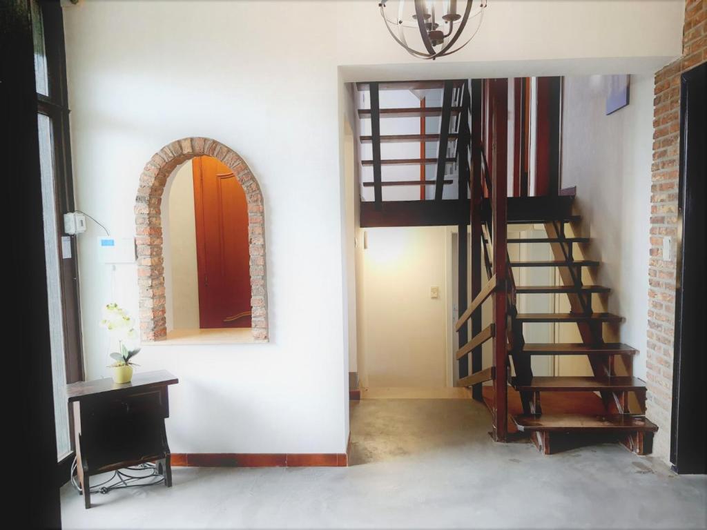 a hallway with a spiral staircase and a mirror at Maison de vacances située entre Liège, Tongres et Visé 