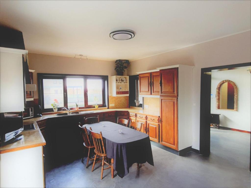 a kitchen with a table and some chairs in it at Maison de vacances située entre Liège, Tongres et Visé 