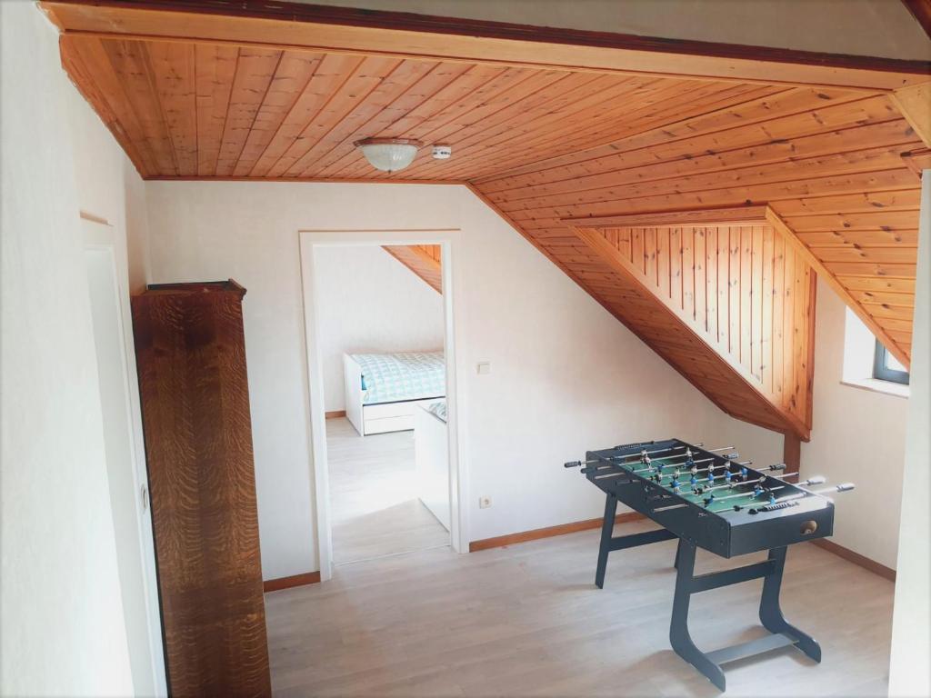 a room with a ping pong table in a attic at Maison de vacances située entre Liège, Tongres et Visé 