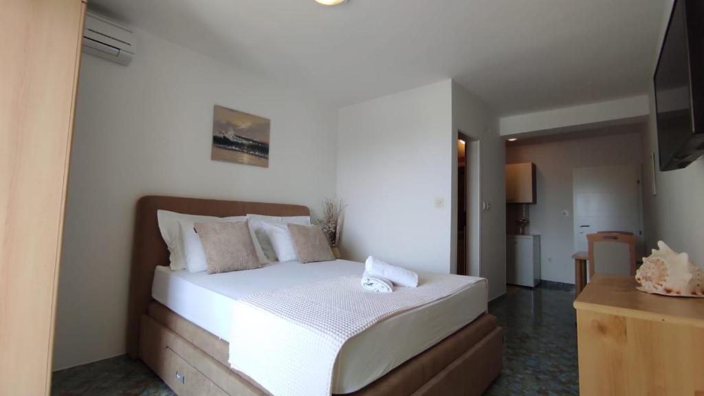 a bedroom with a bed with white sheets and pillows at APARTMAN SUNCE in Baška Voda