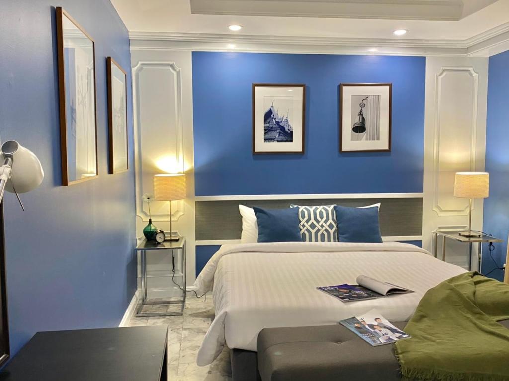 - une chambre avec des murs bleus et un grand lit dans l'établissement Asoke Residence Sukhumvit by UHG, à Bangkok