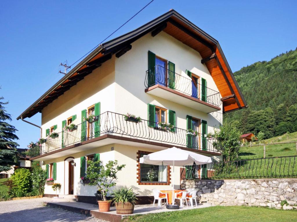 una casa in montagna con tavoli e un ombrello di Holiday Home Sonnhaus by Interhome a Ossiach