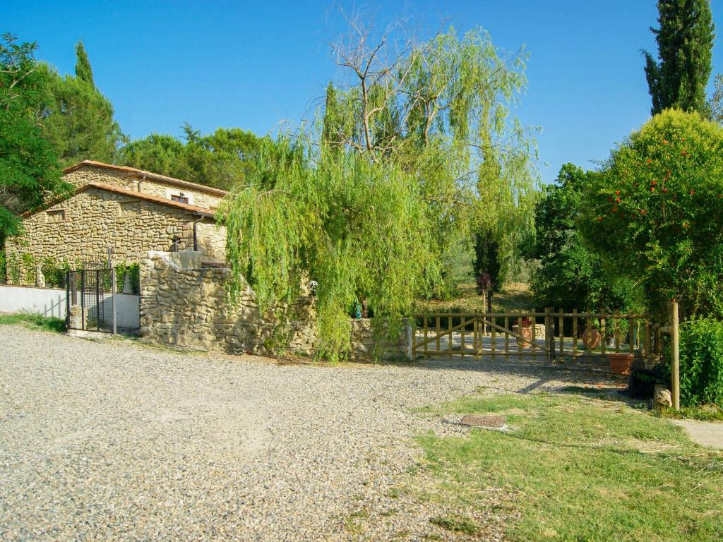 ein Steinhaus mit einem Zaun und einem Baum in der Unterkunft Holiday Home Villa Sofia by Interhome in Volterra