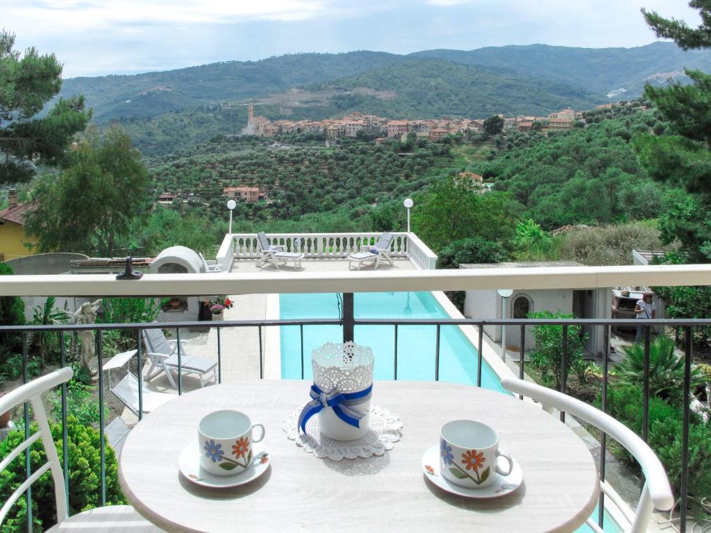 une table avec des tasses et des soucoupes sur un balcon dans l'établissement Apartment Arancio di Liguria - PGI211 by Interhome, à Civezza