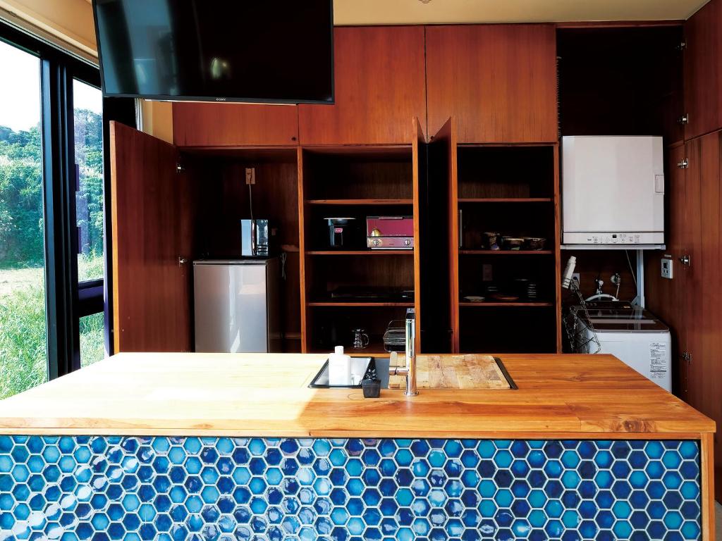 a kitchen with a island with a counter top at CHULAX OKINAWA YOMITAN【Designer Condominium Hotel】 in Yomitan