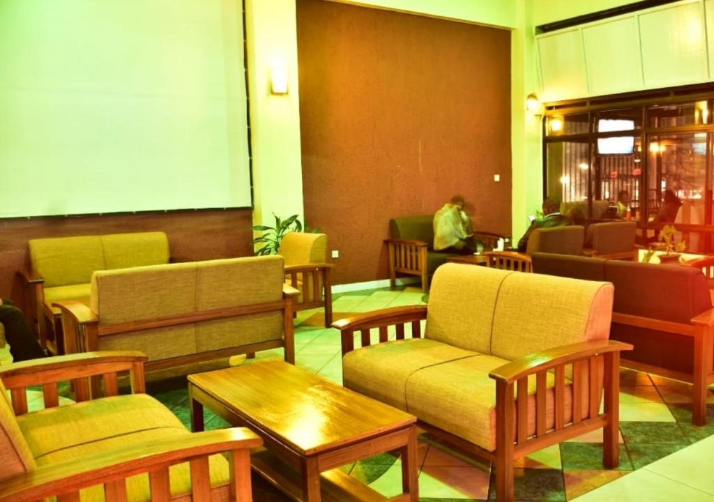 un vestíbulo con sillas y mesas en un restaurante en Klique Hotel Eldoret, en Eldoret