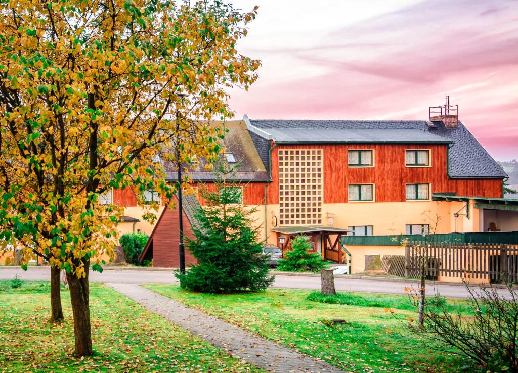 una casa con un árbol delante de ella en Ferienhotel Goldhübel, en Neuhausen