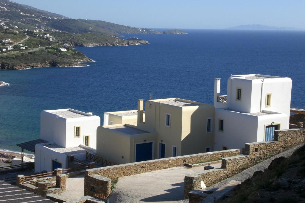 a group of white buildings next to the ocean at Monolithos Villas in Kipri