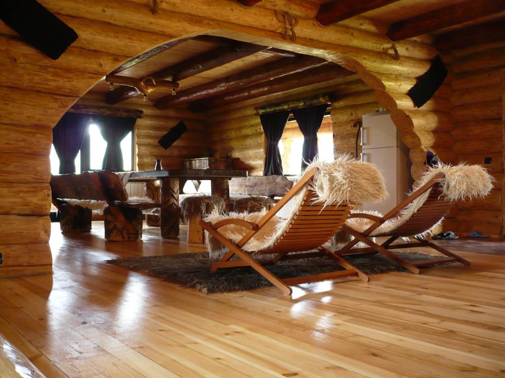 dwa bujane krzesła w pokoju w drewnianej kabinie w obiekcie Cabana Vultur w mieście Vatra Dornei