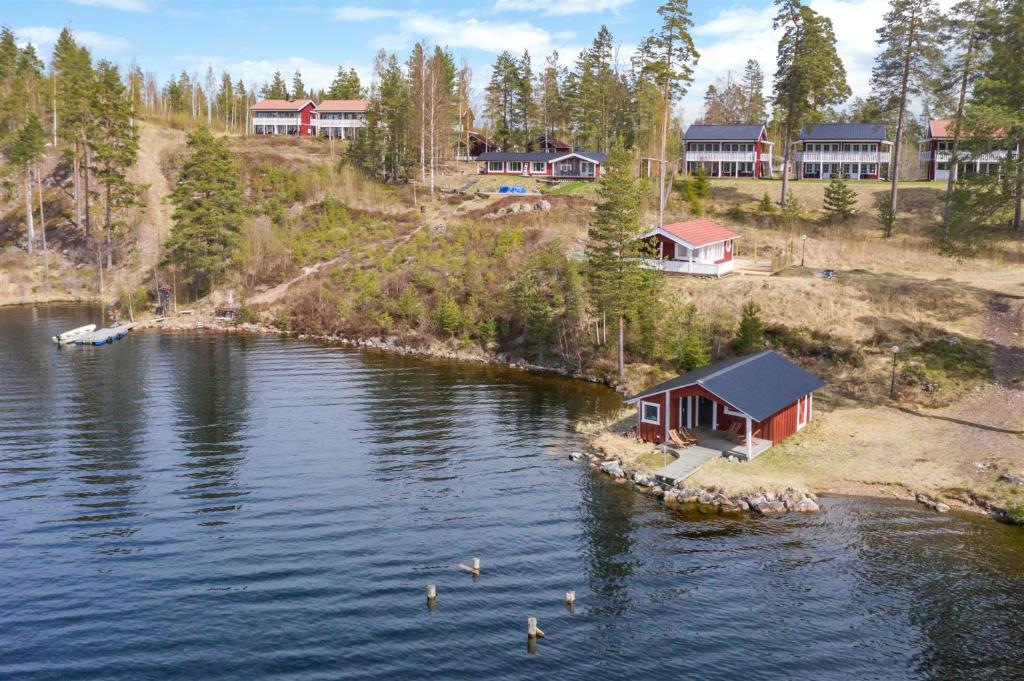 una casa a orillas de un lago con patos en el agua en Rämsbyns Fritidsområde - Den perfekta platsen för avkoppling en Idkerberget