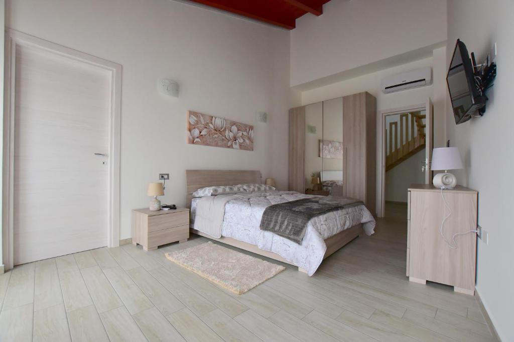 sypialnia z łóżkiem i telewizorem w obiekcie B&B La Genuina w mieście Guspini