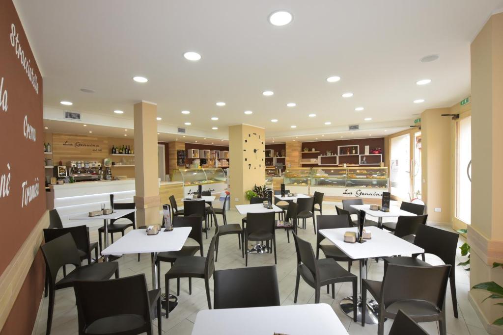 jadalnia ze stołami i krzesłami w restauracji w obiekcie B&B La Genuina w mieście Guspini