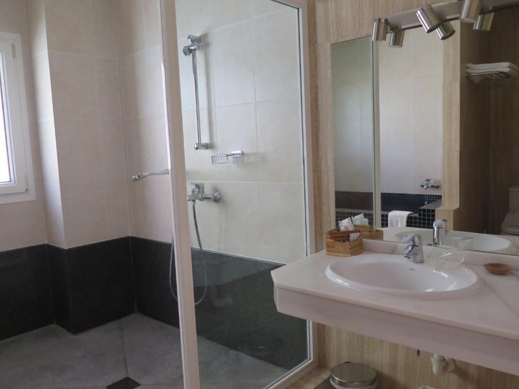 a bathroom with a sink and a shower with a glass door at La Luna Blanca in Torremolinos