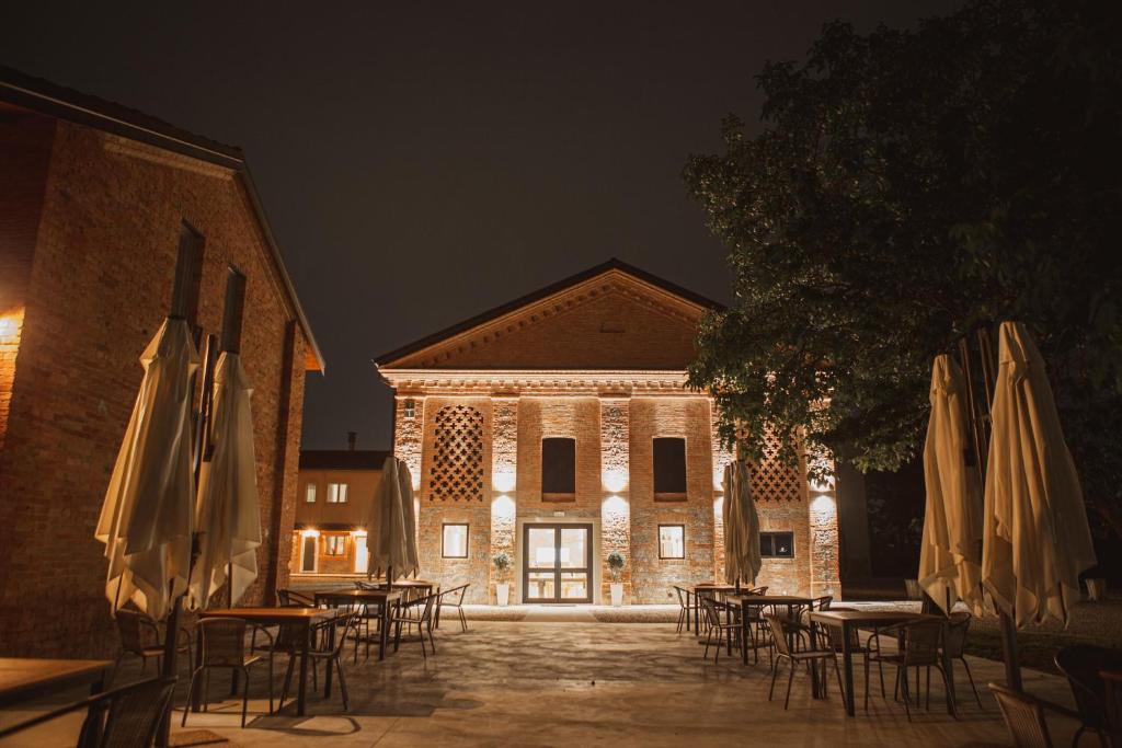 Carpaneto PiacentinoAgriturismo Il Capitolo的一组桌子和伞在建筑前