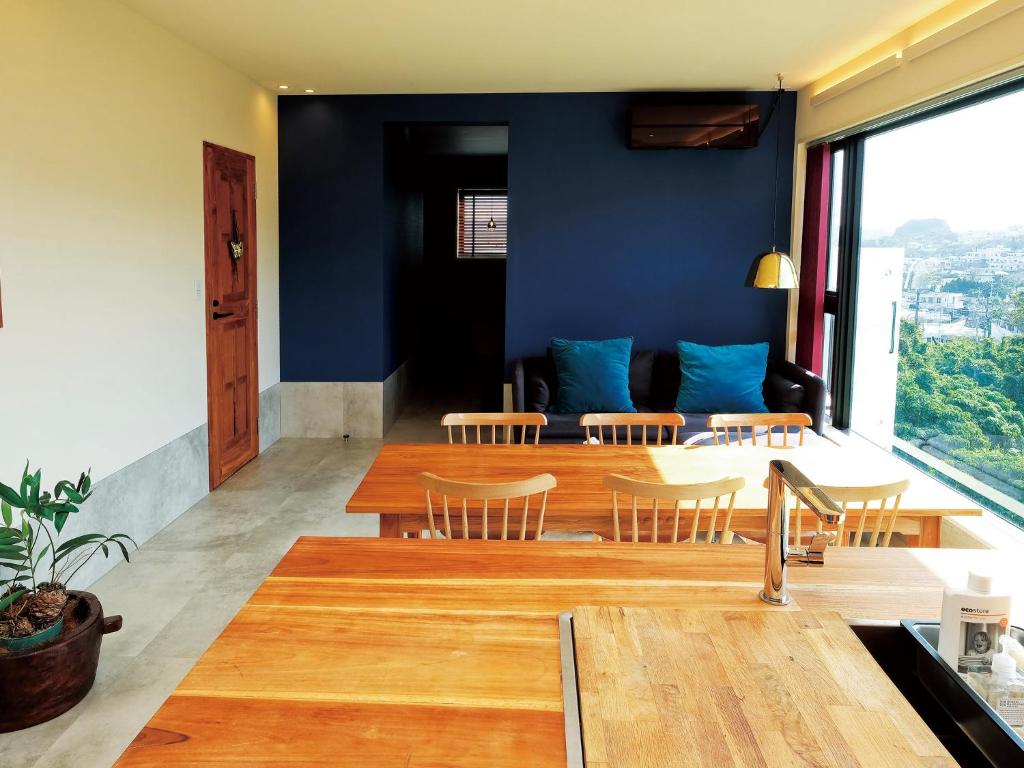 a dining room with blue walls and a table and chairs at CHULAX OKINAWA YOMITAN【Designer Condominium Hotel】 in Yomitan