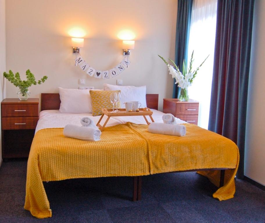 a bedroom with a bed with two towels on it at Hotel Przy Solankach in Grudziądz