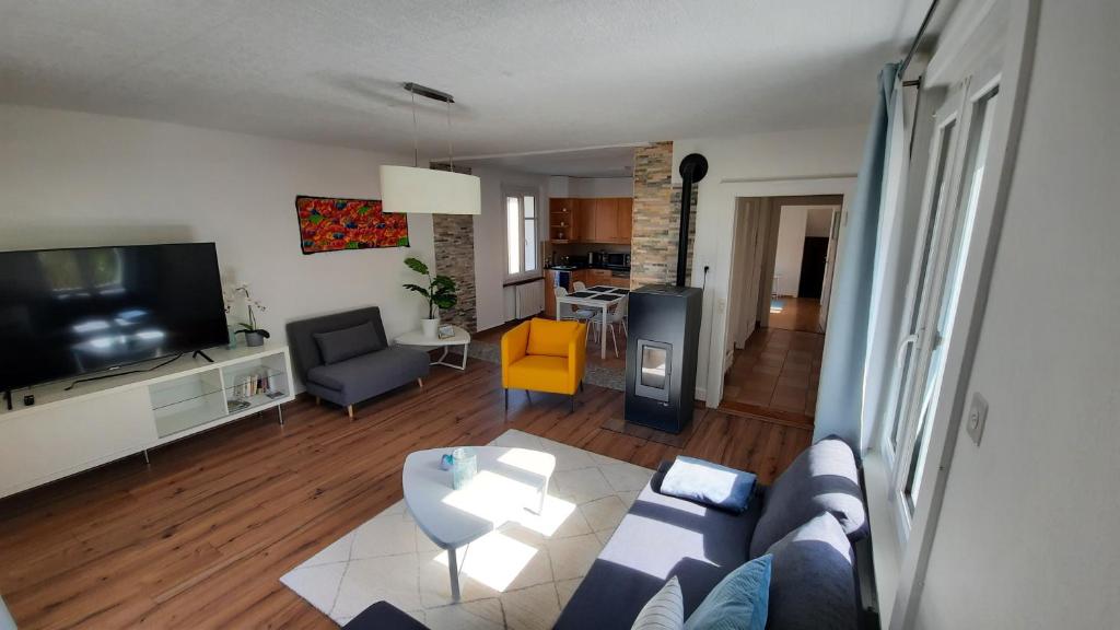 a living room with a couch and a tv at Appartement Le 18 in Ependes