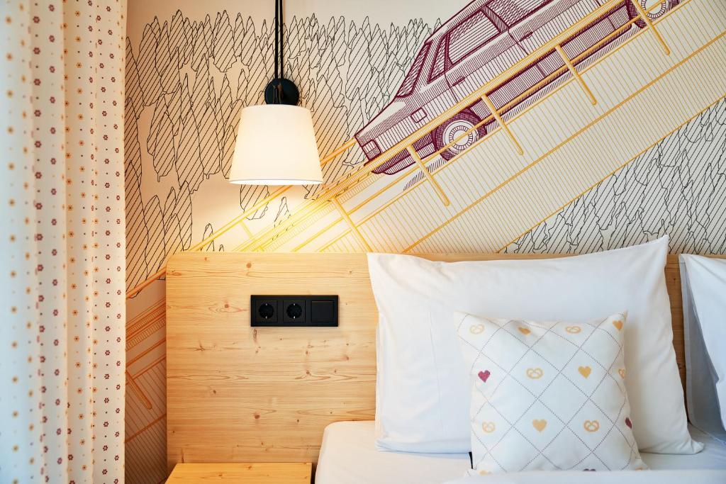 ein Schlafzimmer mit einem Bett mit einem Auto an der Wand in der Unterkunft McDreams Hotel Ingolstadt in Ingolstadt