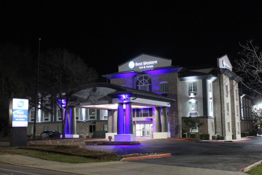Best Western Medical Center North Inn & Suites Near Six Flags في سان انطونيو: مبنى أمامه أضواء أرجوانية