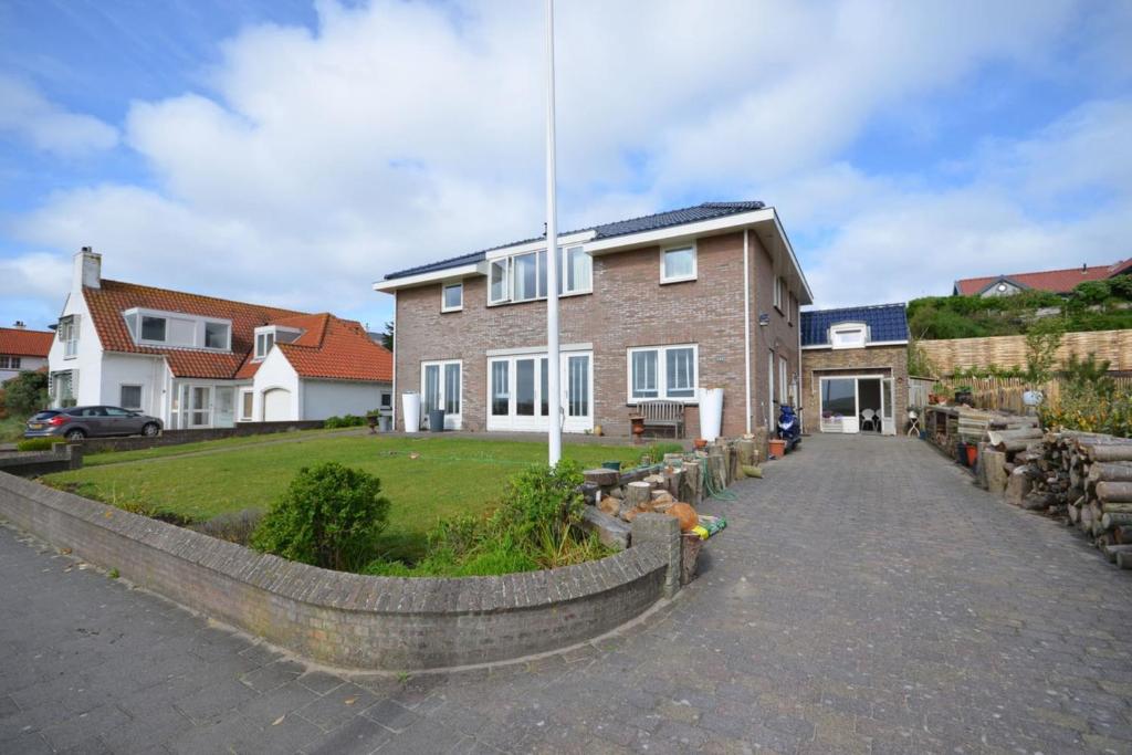 a brick house with a fence in front of it at Anne's Huisje with private parking in Zandvoort