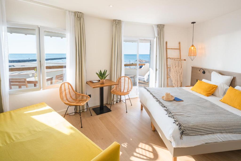 Schlafzimmer mit einem Bett und einem Tisch mit Stühlen in der Unterkunft Hôtel Casa Marina in Saintes-Maries-de-la-Mer