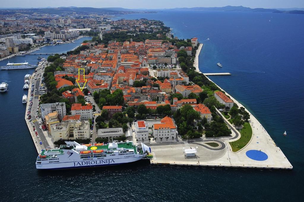 an island with a cruise ship in the water at Rooms Tisa Old Town in Zadar