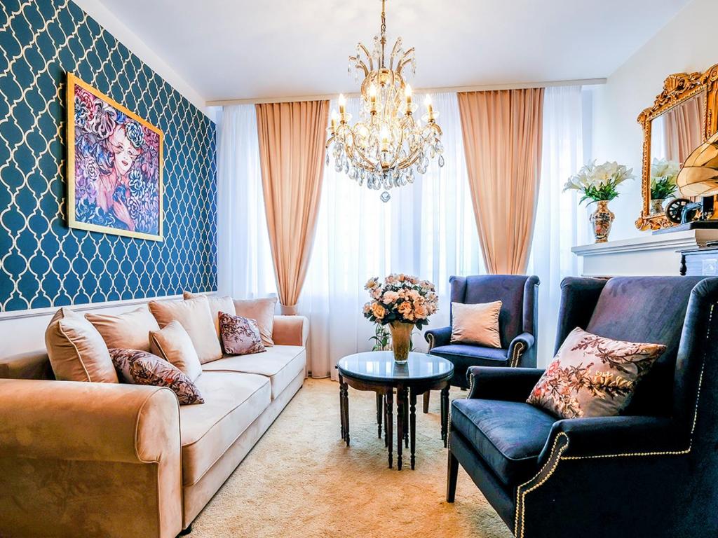 a living room with a couch and chairs and a chandelier at Zatoka Aniołów in Łeba