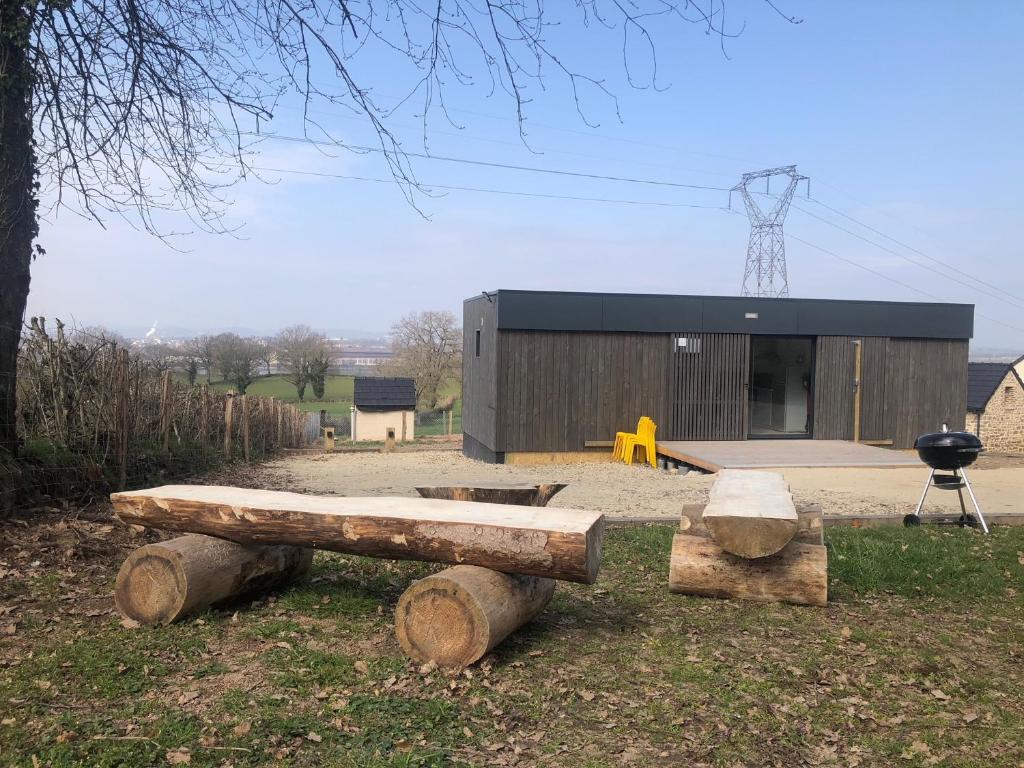 a log bench in front of a building with a grill at Le Banc Bourguignon in Saint-Leu