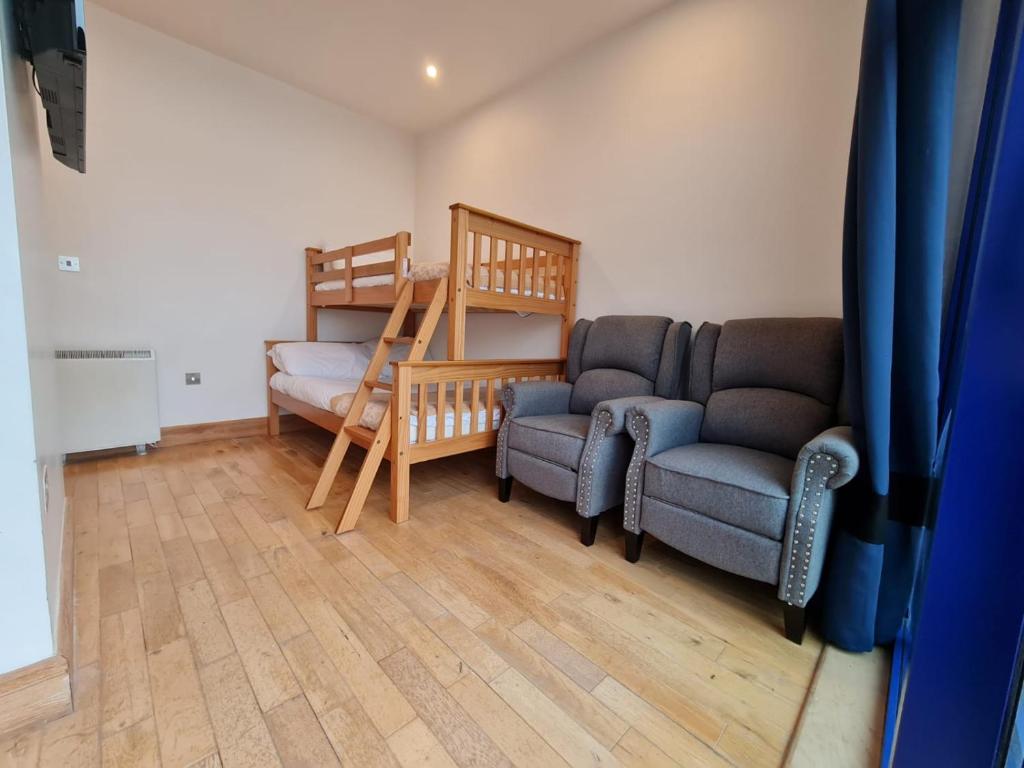 a living room with two chairs and a bunk bed at Carlingford Marina Apartments in Carlingford