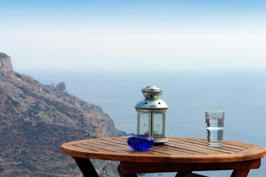 una lanterna seduta su un tavolo con un bicchiere di Anatoli ad Áno Meriá