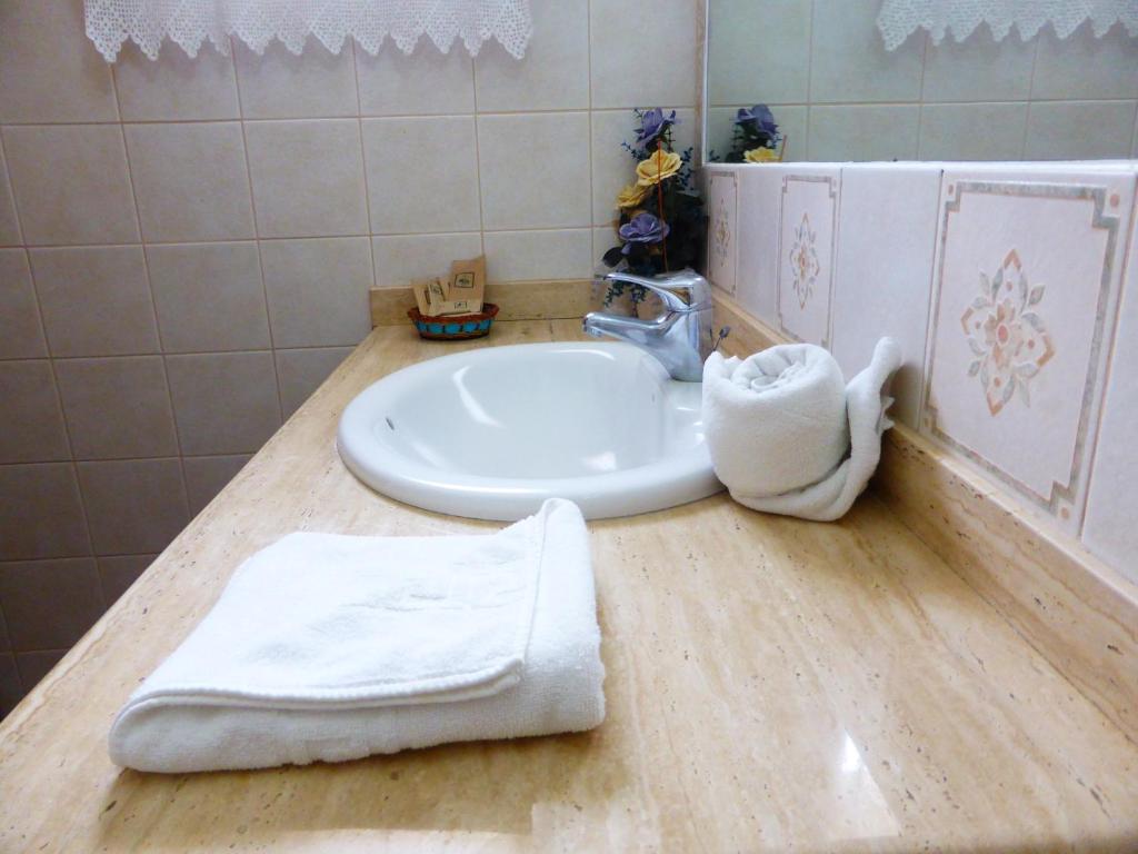 アルカラにあるHotel Rural El Navío - Adults Onlyのバスルーム(シンク、カウンターの白いタオル付)