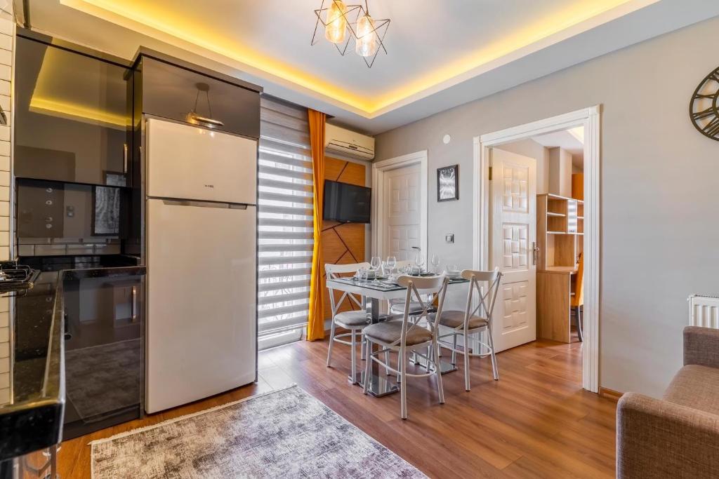 a kitchen and dining room with a white refrigerator and a table at Umut Apartments in Trabzon