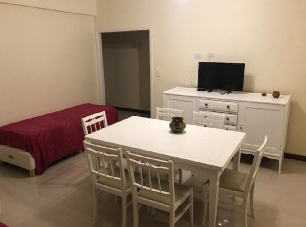 Departamentos Premium - 2 Ambientes - Excelente ubicación في ميرامار: غرفة مع طاولة وغرفة نوم مع سرير