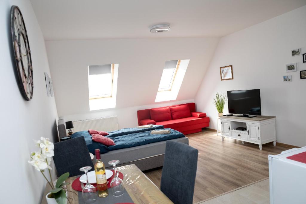 a living room with a couch and a red sofa at Kossuth Apartmanház in Tata