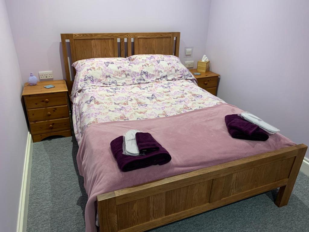 a bed in a bedroom with two dressers and a bedspread at Sea Shells in Greatstone