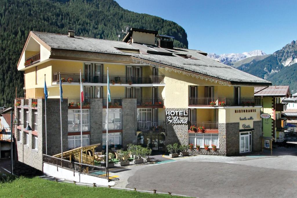 un hotel en las montañas con un estacionamiento en Hotel Bellevue, en Canazei