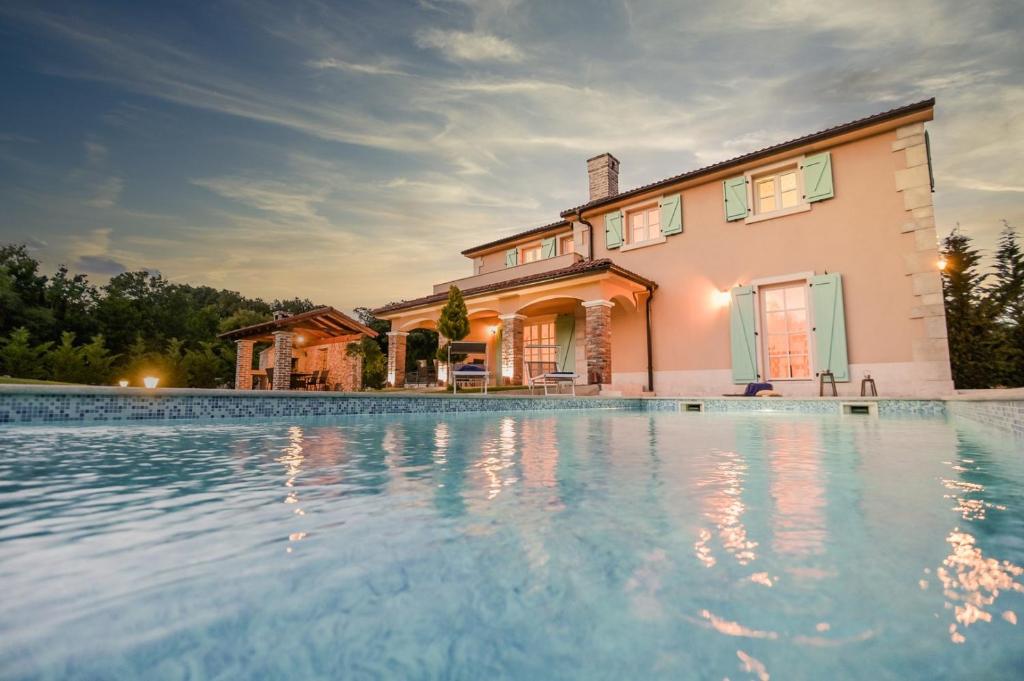 una casa con piscina frente a una casa en Villa Plasa Krk en Kras