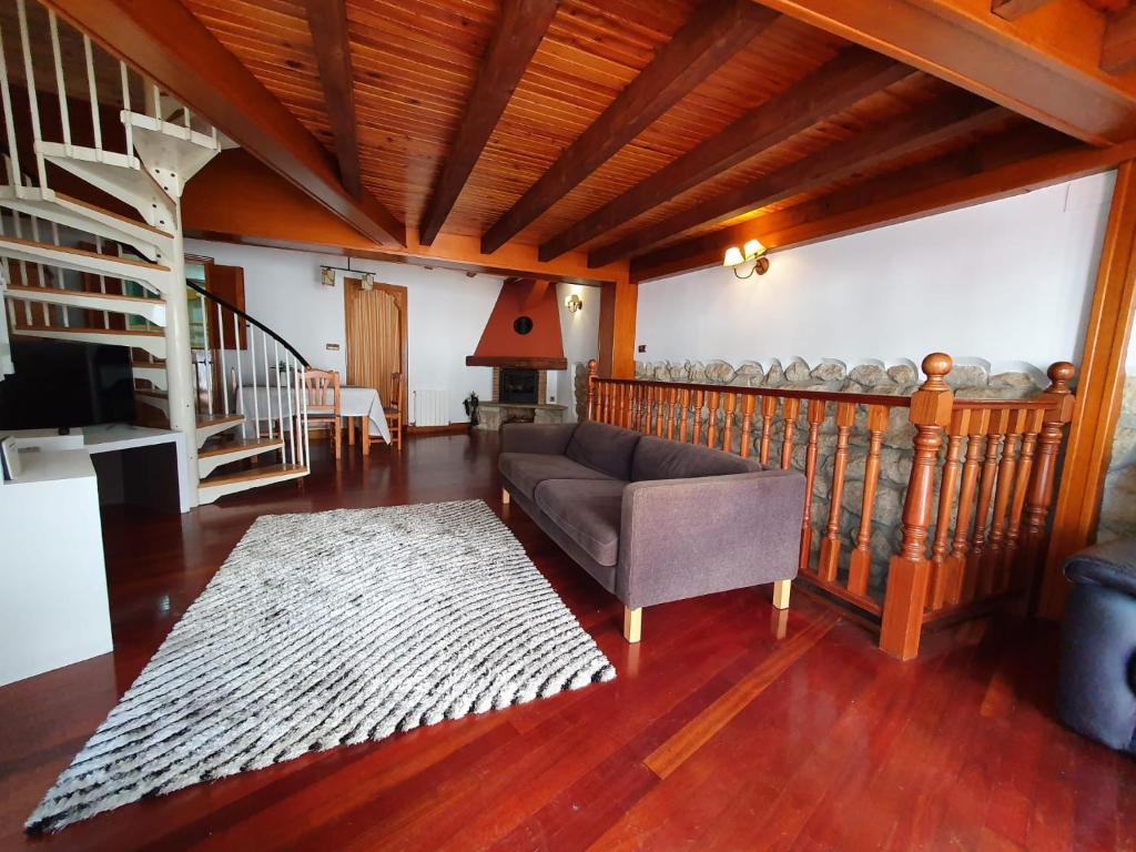 ein Wohnzimmer mit einem Sofa und einer Treppe in der Unterkunft Gernika Urdaibai in Gernika