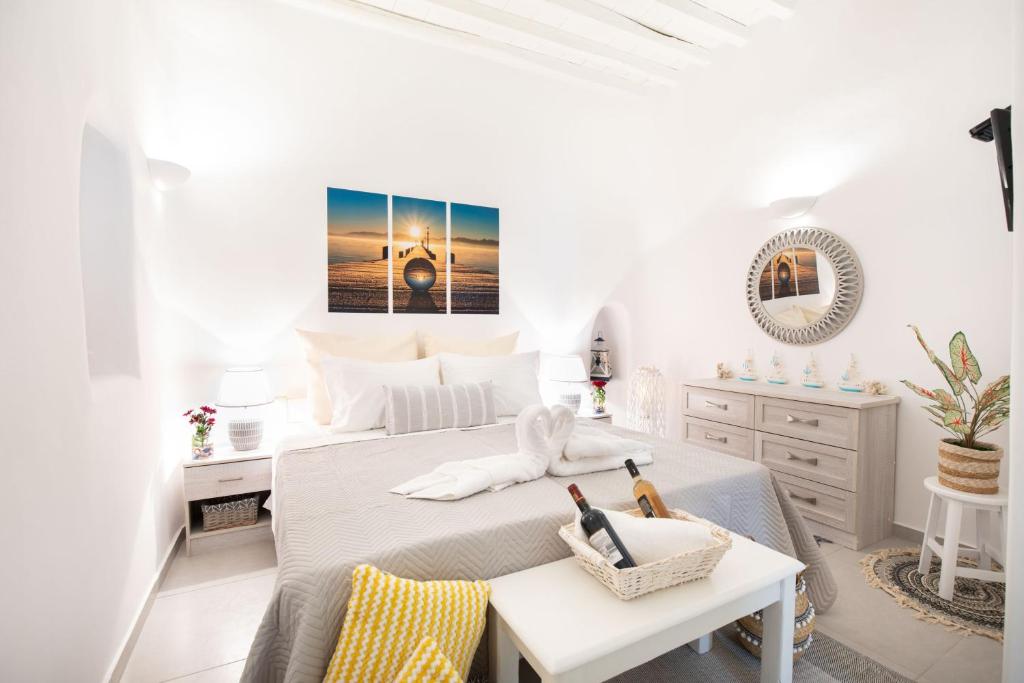 biała sypialnia z łóżkiem i stołem w obiekcie Sole Blu Mykonos Town Apartment One w mieście Mykonos