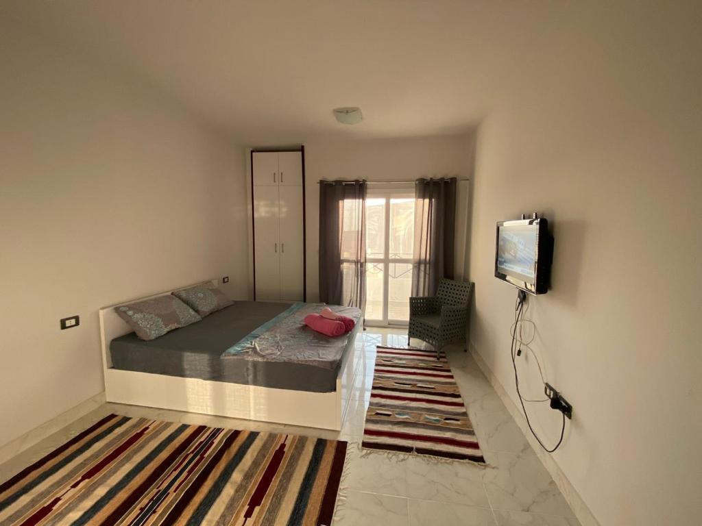 a bedroom with a bed and a tv on a wall at Tiba View in Hurghada