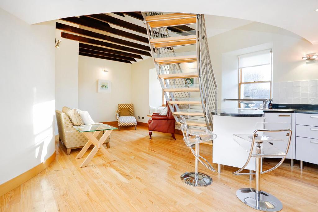 eine Wendeltreppe in einem Zimmer mit einer Küche in der Unterkunft JOIVY Unique Mezzanine Apartment in St Andrews in St Andrews