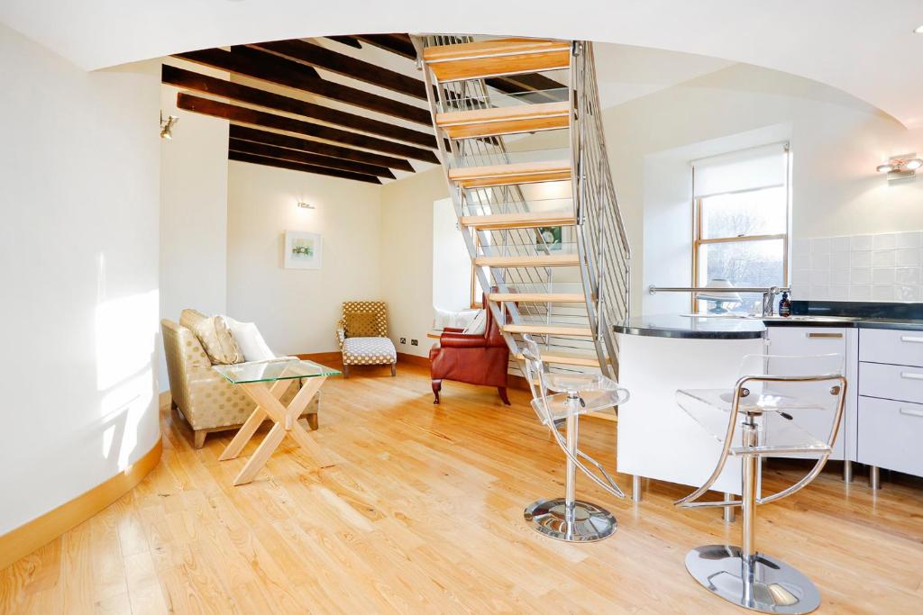 a spiral staircase in a room with a kitchen at ALTIDO Unique Mezzanine Apartment in St Andrews in St Andrews