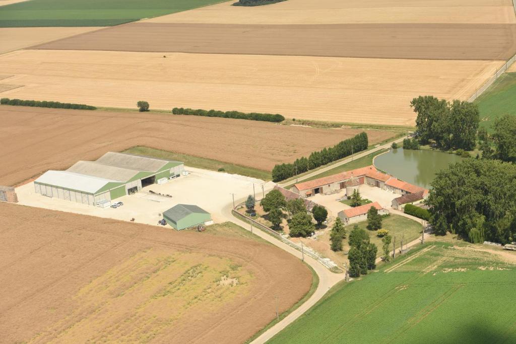 an overhead view of a farm with a field and a building at Ferme de Mesangeon in Beauvilliers