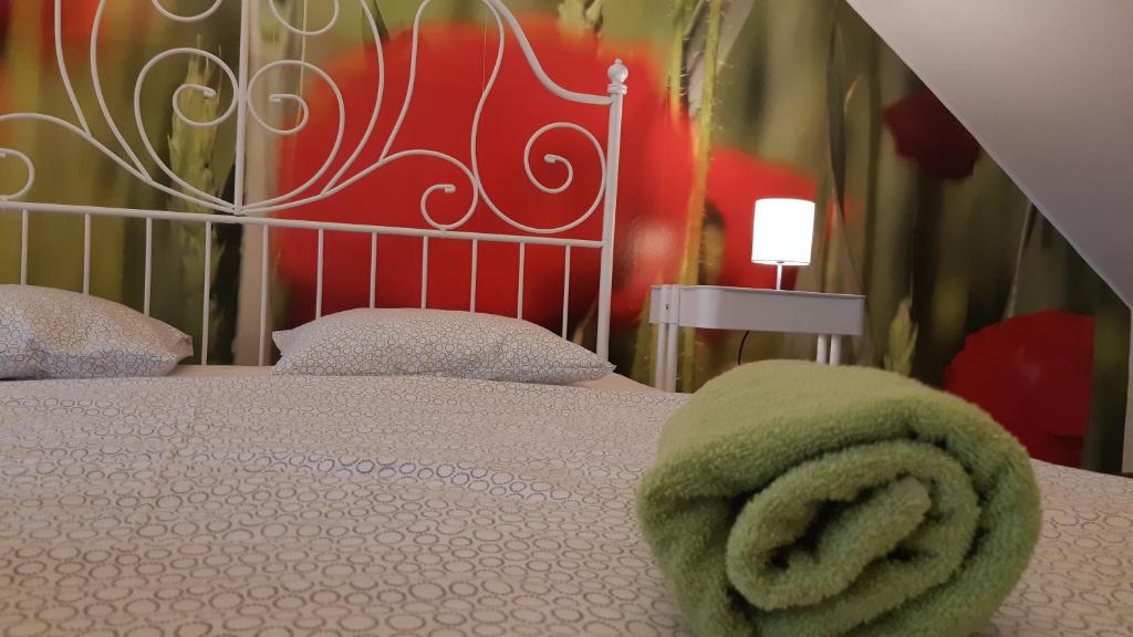 バラトンフレドにあるMediterran Medencés Nyaralóのベッドルーム1室(ベッド1台、緑のタオル付)