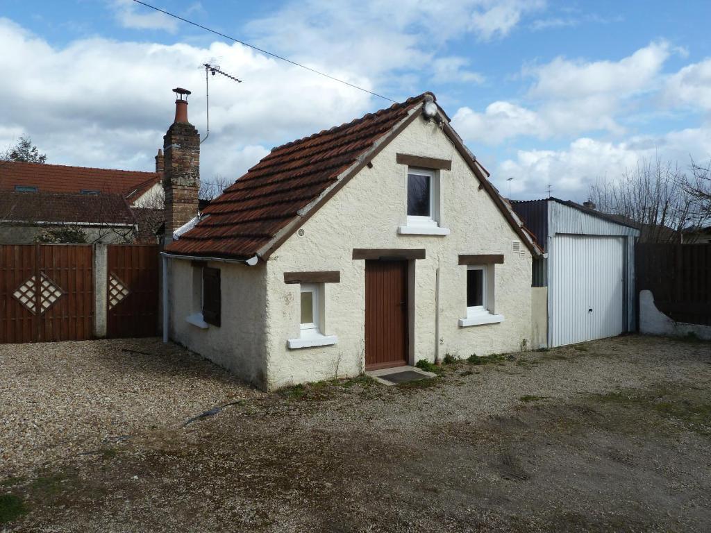 a small white house with a red door at La Petite maison en Sologne in Salbris