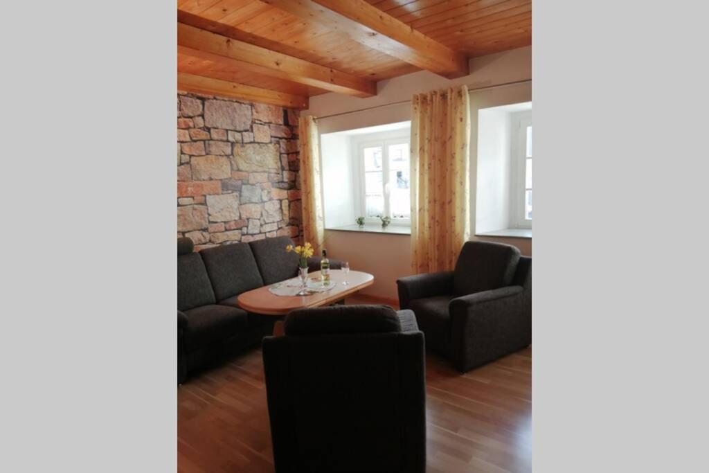 Sala de estar con 2 sofás y mesa en Quartier am Markt- Ferienwohnung, en Bad Gottleuba