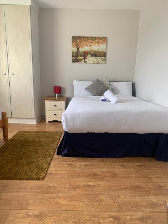 um quarto com uma grande cama branca e um tapete em Newcastle Townhouse em Galway