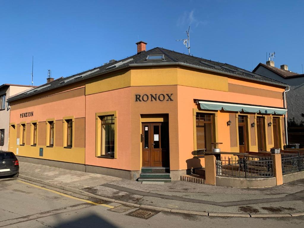 un edificio amarillo y naranja al lado de una calle en Penzion Ronox, en Česká Skalice