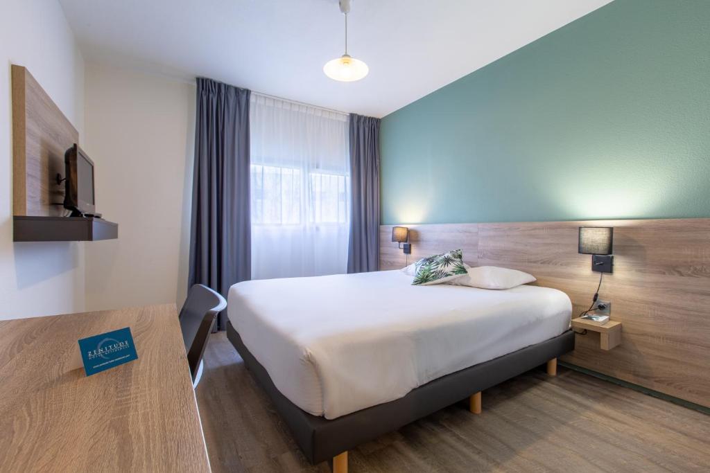 Säng eller sängar i ett rum på Zenitude Hôtel-Résidences Le Mans Novaxis